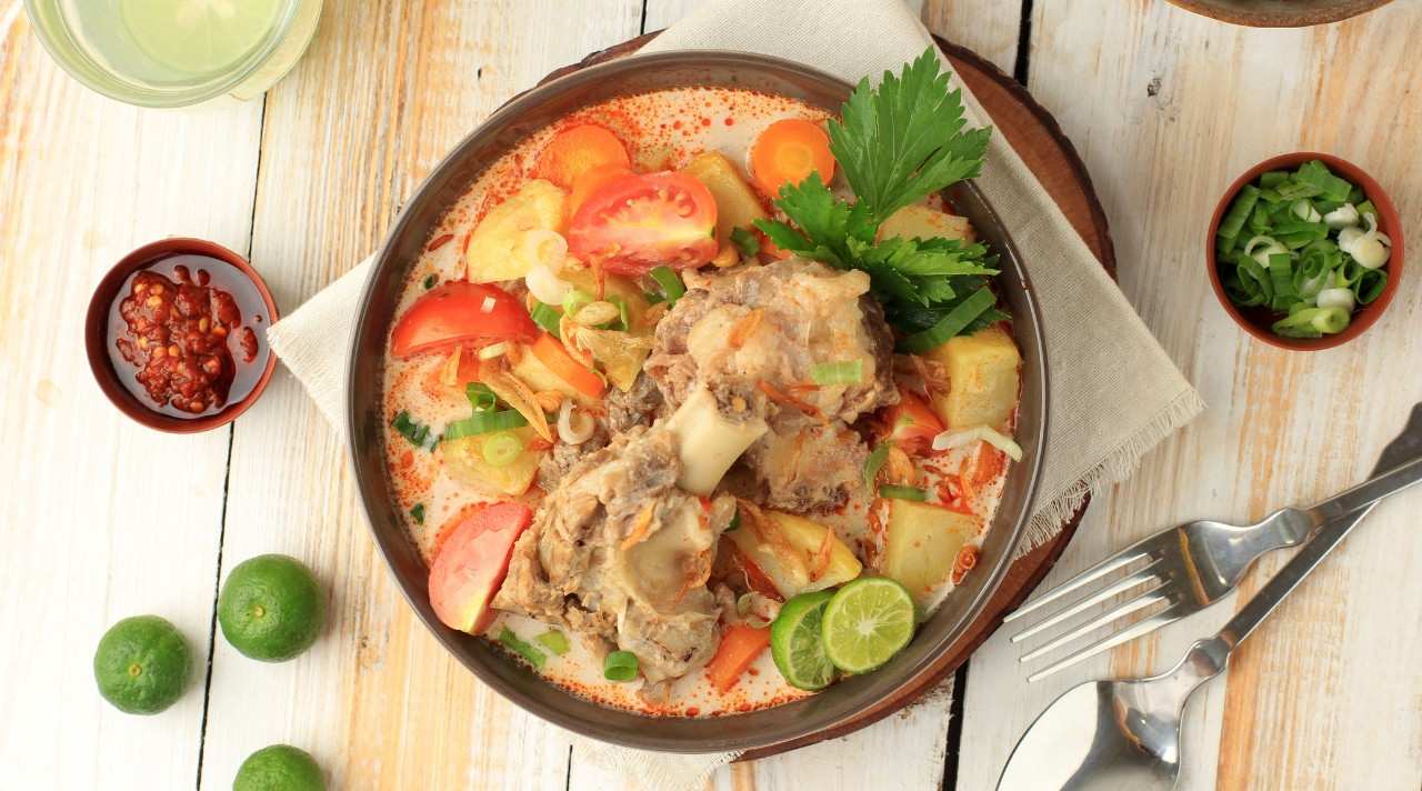 Semangkuk Soto Betawi dengan kuah gurih creamy, potongan daging sapi empuk, dan taburan bawang goreng yang menggugah selera khas kuliner Betawi.